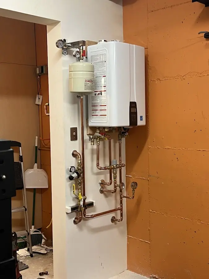 Plumbing technician inspecting water heater connections in Bishop